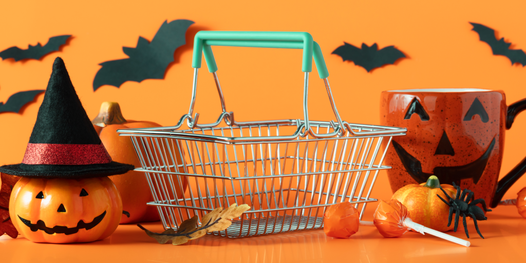 A shopping cart with a carved pumpkin and Halloween decorations. 