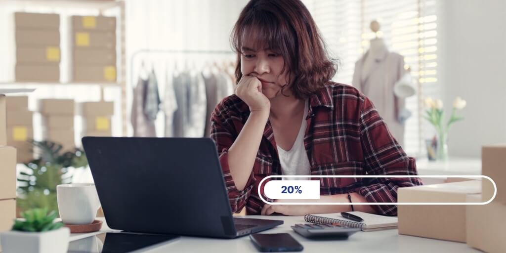 A woman sitting at a table in front of a laptop. On her right side is a progress bar showing that the transfer's progress is at 20%.