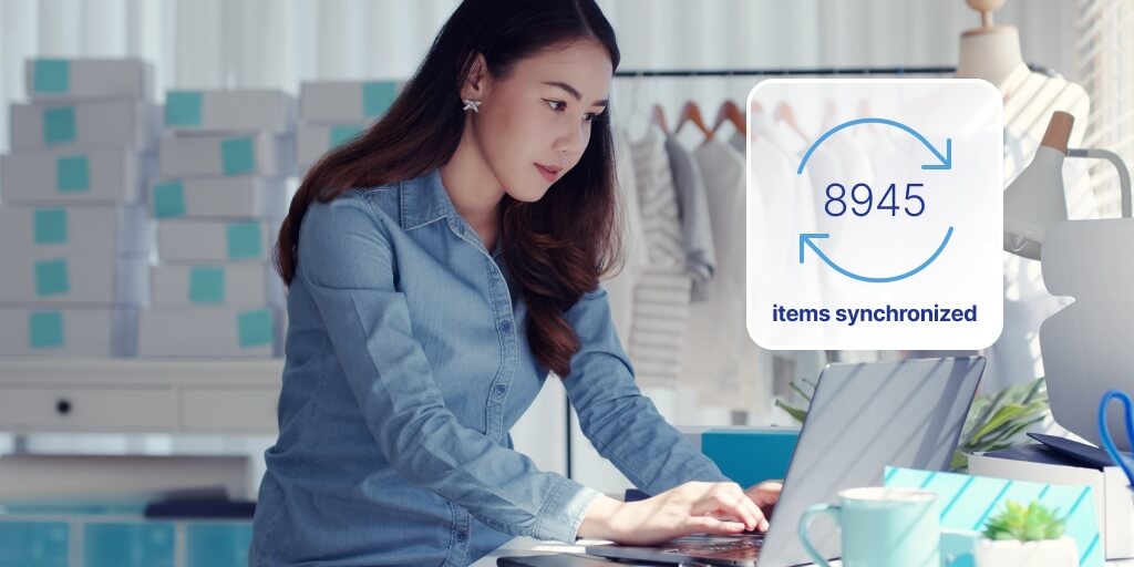 A woman sitting in front of a laptop. A text overlay on her right side reads '8945 items synchronized'.